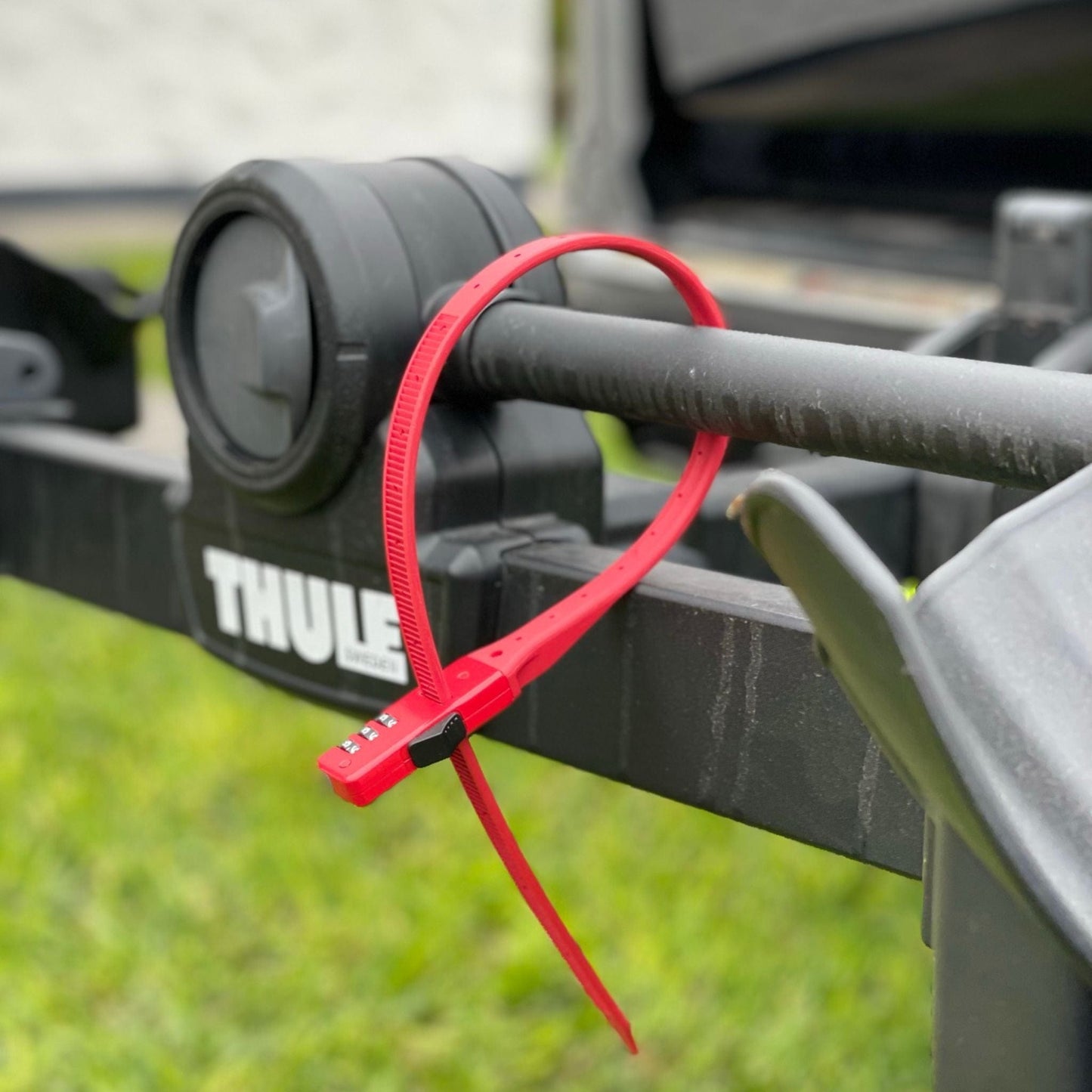 Candado Bell QuickZip rojo asegurando una bicicleta en un portabicicletas Thule