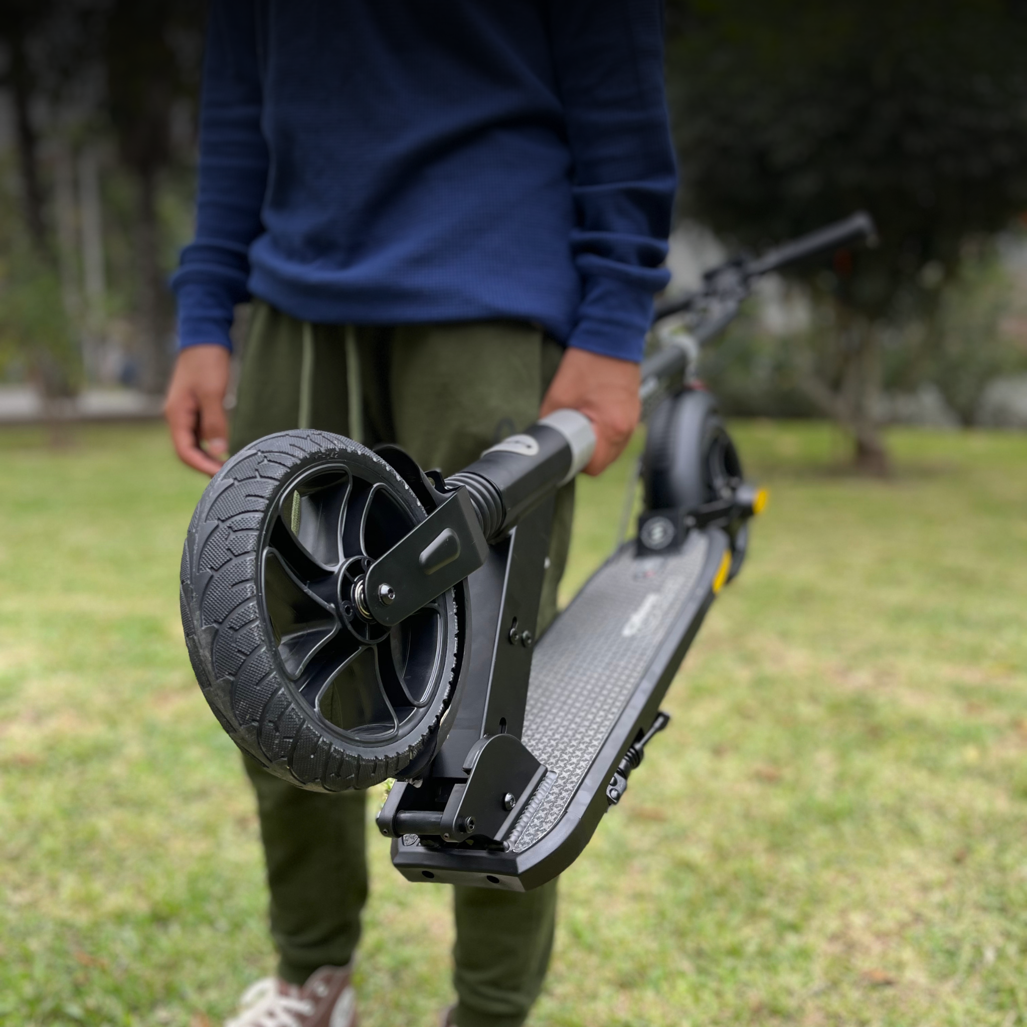 niño con scooter de dos ruedas en el parque